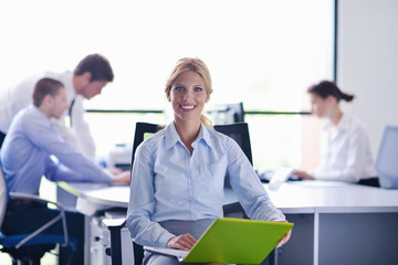 Obraz premium business woman with her staff in background at office