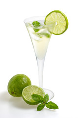 Aperitif mit Limetten und Minze in einer Sektflöte