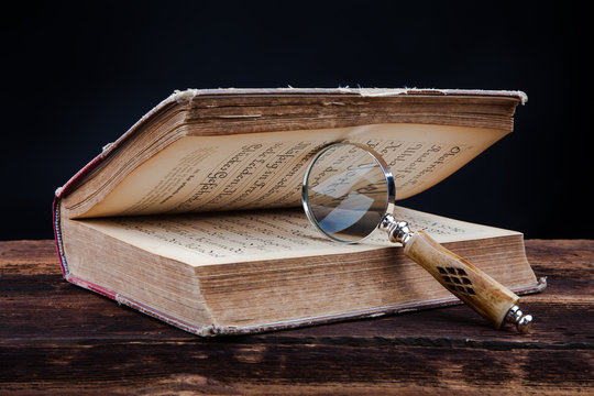 magnifing glass and old book