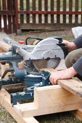 Carpenter sawing plank