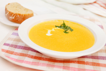 Pumpkin soup in white bowl