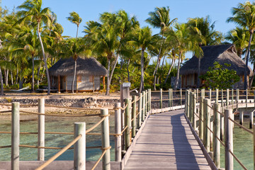 Fototapeta premium The wooden road over the sea to the tropical island. Polynesia