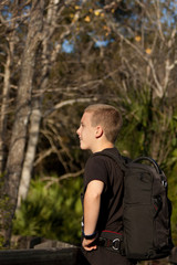 Boy with backpack looking at nature
