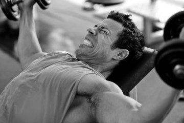 bodybuilder hard training in the gym: incline dumbbell press