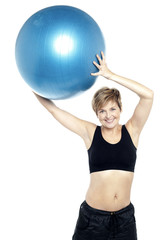 A healthy woman lifting big swiss ball