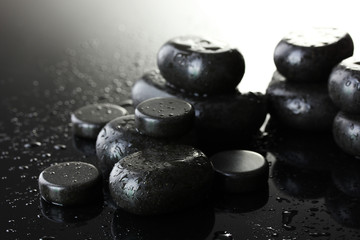 Spa stones with drops on grey background