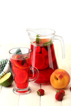 sangria in jar and glass with fruits,