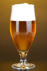Glass of beer on yellow background