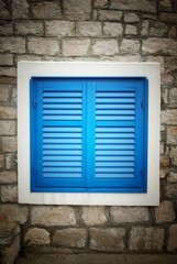 Fototapeta premium Blue shutters in old stone house