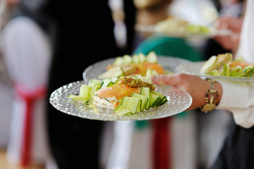 Waitress carrying plates with fish dish