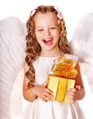 Child at angel costume holding gift box.