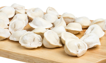 Fototapeta na wymiar Some raw dumplings on the wooden board