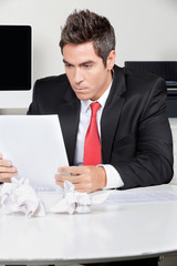 Businessman Reading Document In Office