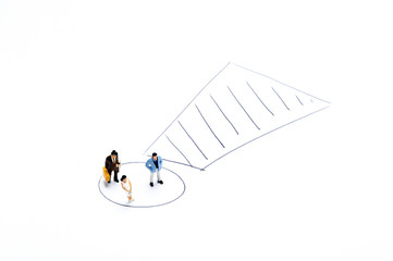 Miniature people on white with some diagrams