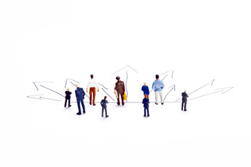 Miniature people on white with some diagrams