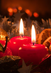 Two candles and christmas decorations.