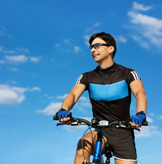 Fototapeta na wymiar Man Riding a Bike on Sky Background