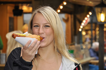 Junge Frau isst Bratwurst