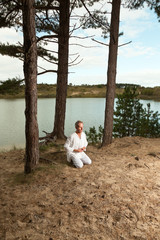 Senior spiritual man dressed in white.Exercising outdoors.