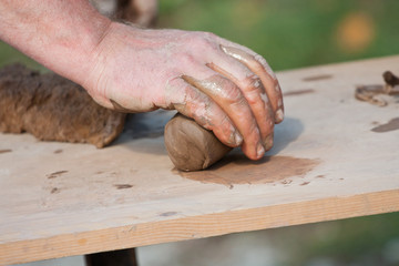 Hand of potter forming wet clay