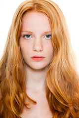 Naklejka premium Pretty fashion girl with long red hair against white background.