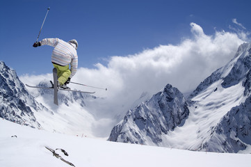 Fototapeta na wymiar Freestyle skoczek ze skrzyżowanymi nartami w wysokich górach