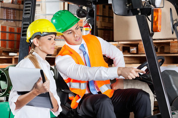 Male Supervisor Showing Something To Colleague At Warehouse