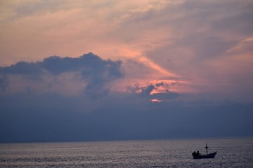 Barca al tramonto sullo stretto di Messina