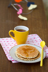 Round wafers, yellow cup with spoon on a napkin