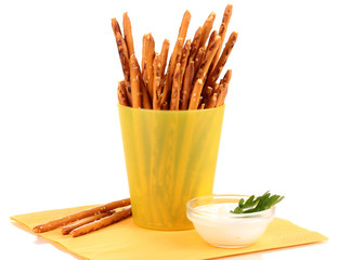 Tasty crispy sticks in yellow plastic cup isolated on white