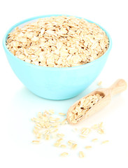 Blue bowl full of oat flakes with wooden scoop isolated on