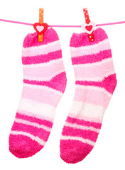 Pair of striped socks hanging on a rope isolated on white