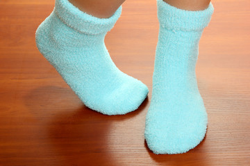 Legs female in blue socks on laminate floor