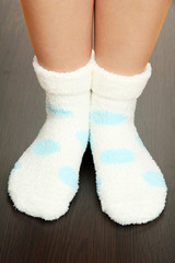Legs female in socks with polka dots on laminate floor