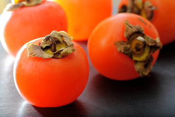Close up fuyu persimmons fruits on black background