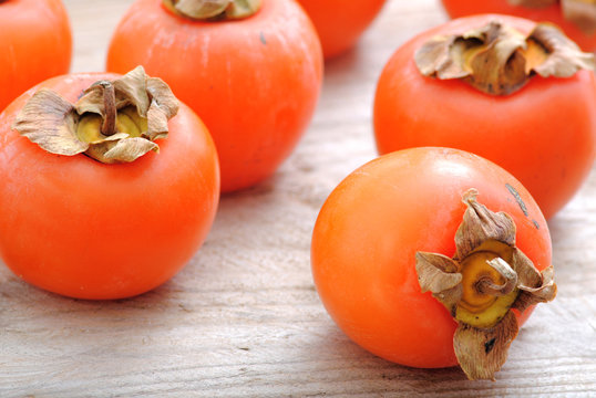 Close Up Fuyu Persimmons Fruits Whole On White Wood