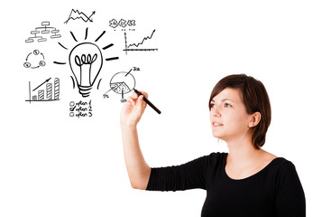 Young business woman drawing light bulb with various diagrams an