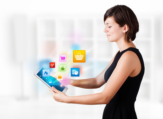 Young woman looking at modern tablet with colourful icons