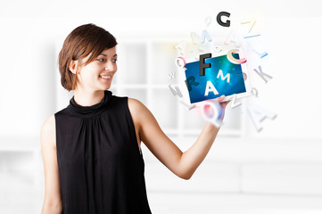 Young woman looking at modern tablet with alphabet