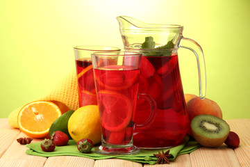 sangria in jar and glasses with fruits,