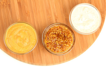 various sauces on chopping board isolated on white