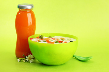 tasty  dieting food and bottle of juice, on green background