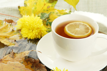 cup of hot drink and autumn leaves, close up