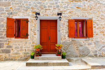 Fototapeta na wymiar dom z drewnianych okien i drzwi, otoczona kamiennym wal