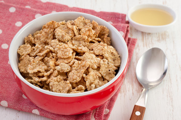 cereals in the bowl with honey and spoon