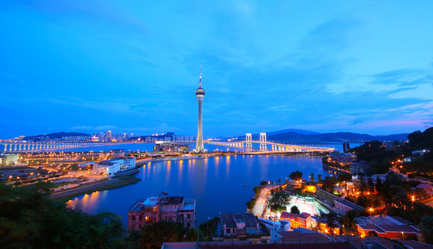 Cityscape in night with famous travel tower near river in Macao,