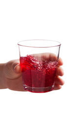 Female hand holding water glass with red liquid drink