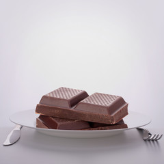 Chocolate bars stack on plate.