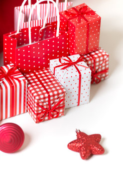 Gift boxes with xmas presents wrapped in red paper with ornament