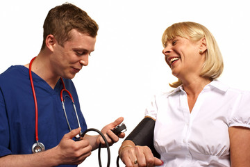 Doctor checking blood pressure of a mature female patient - 46608716